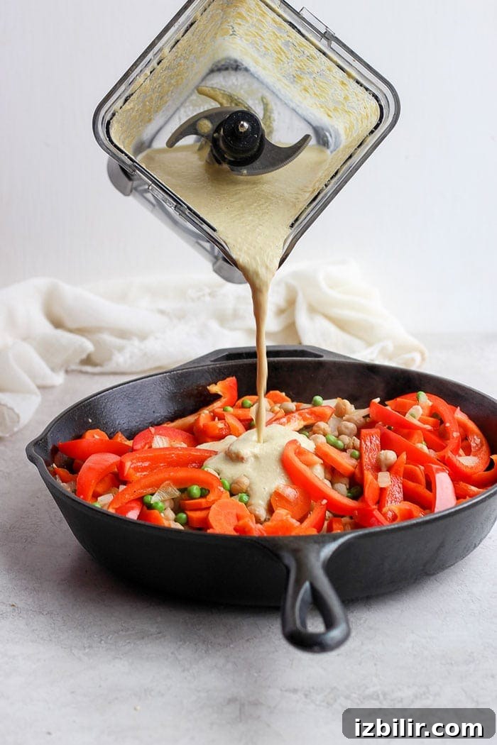Pour the cashew sauce over vegetables creamy cashew curry sauce being poured over sautéed veggies