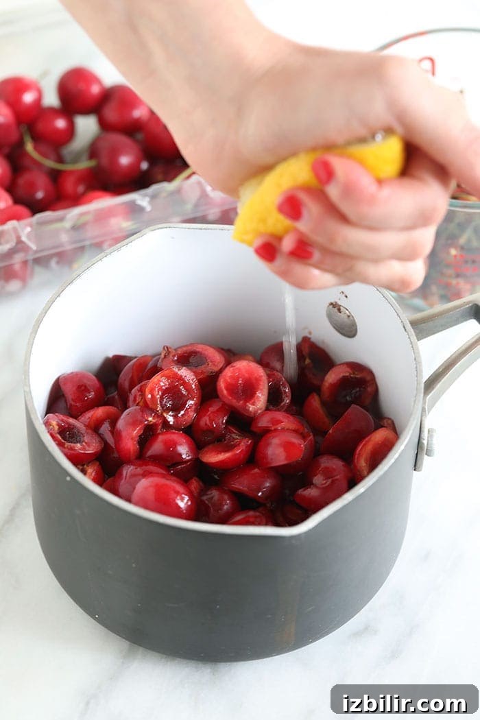 Squeezing lemon juice into cherries squeezing lemon juice into a saucepan of cherries