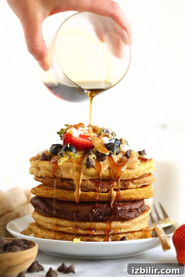 If you love pancakes, add this healthy pancake recipe to the list! This is our favorite pancake base recipe + 6 healthy pancake recipes you can make with it. Start flipping those flapjacks! Pouring syrup onto a stack of pancakes.