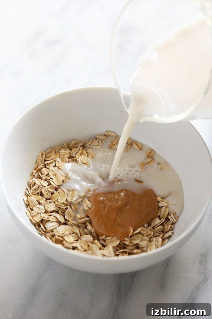 Make Microwave Oatmeal in 2 Minutes 3 adding milk to oatmeal in bowl