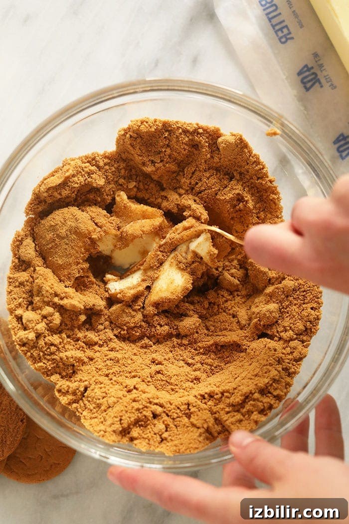 pumpkin cheesecake bar crust being mixed in a bowl