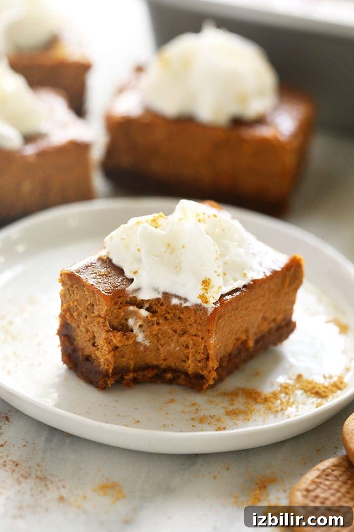 pumpkin cheesecake bar with a bite taken out of it on a plate