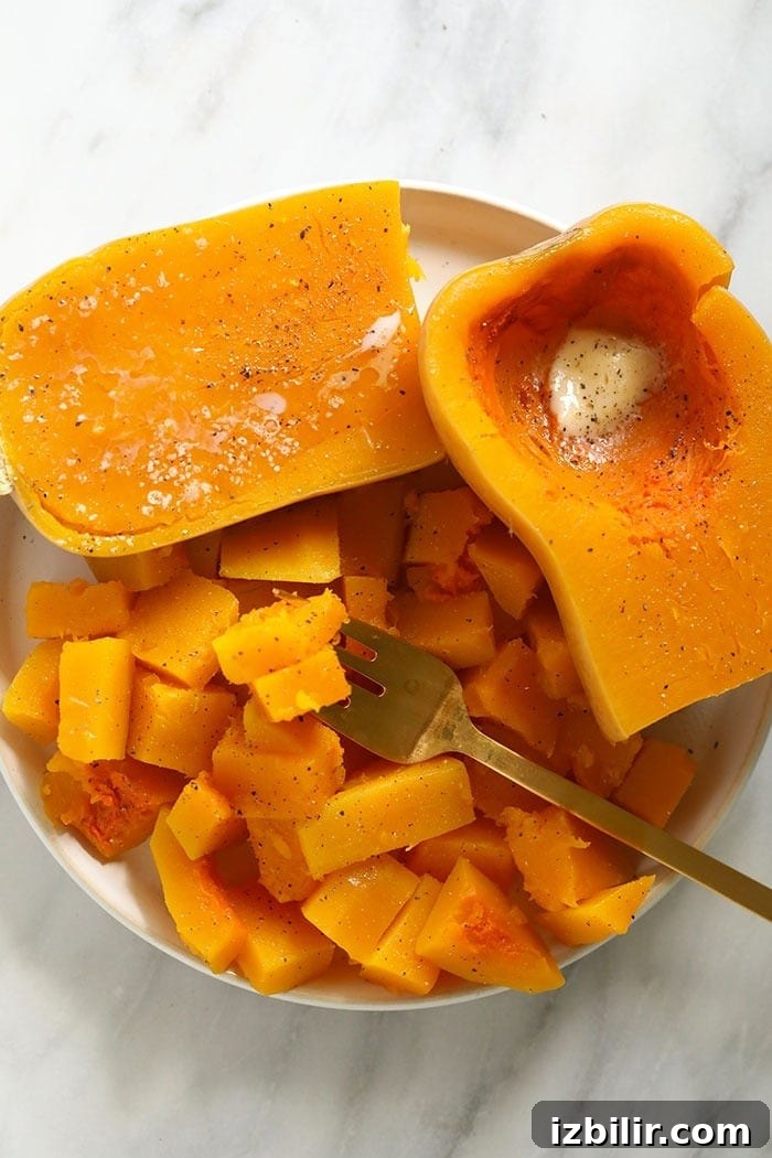 cooked butternut squash on a plate with butter, salt, and pepper