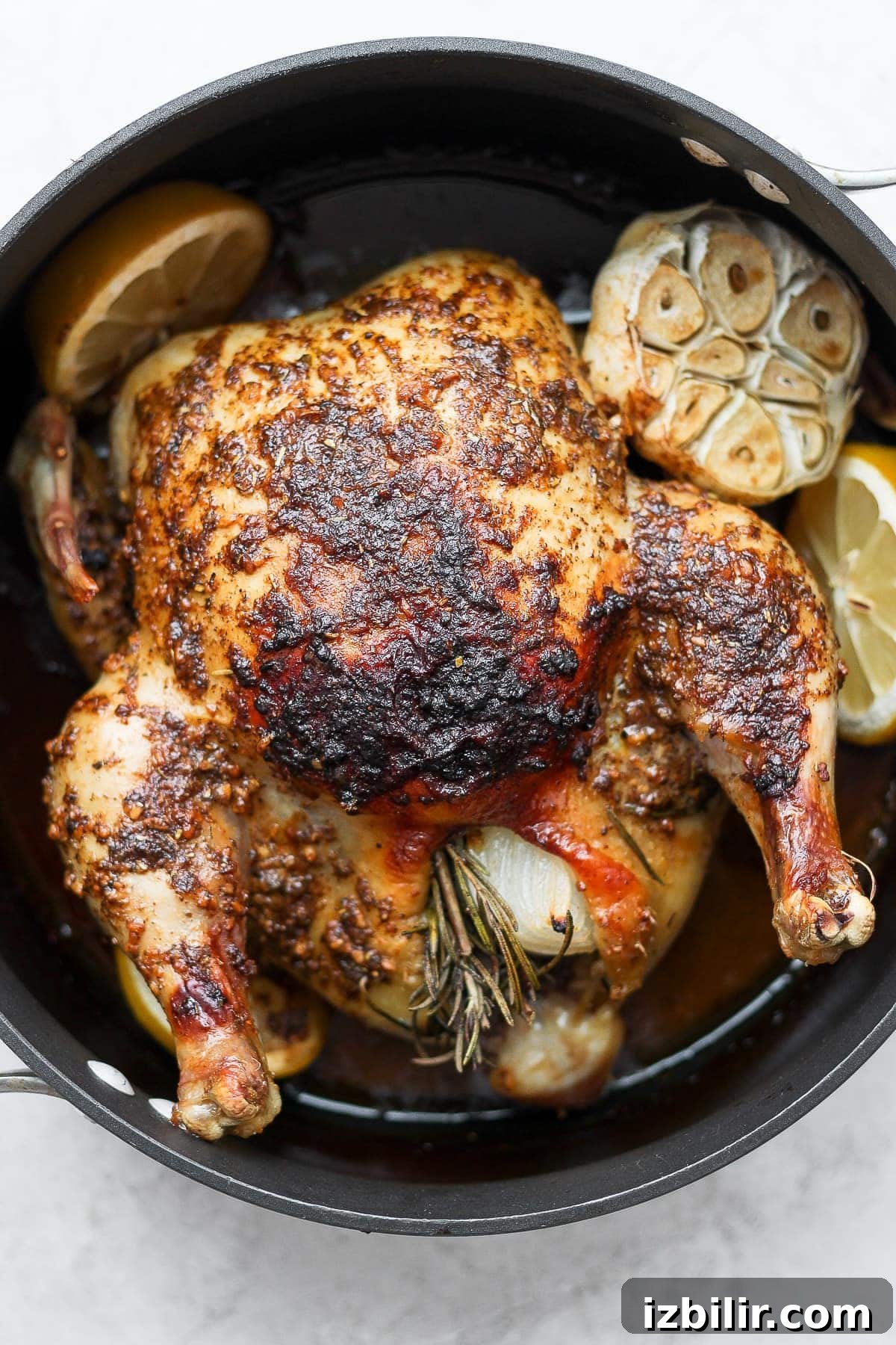 Learn how to roast a whole chicken plus get tips and tricks for flavoring and cooking the most tender whole chicken. whole roasted chicken with garlic in pan