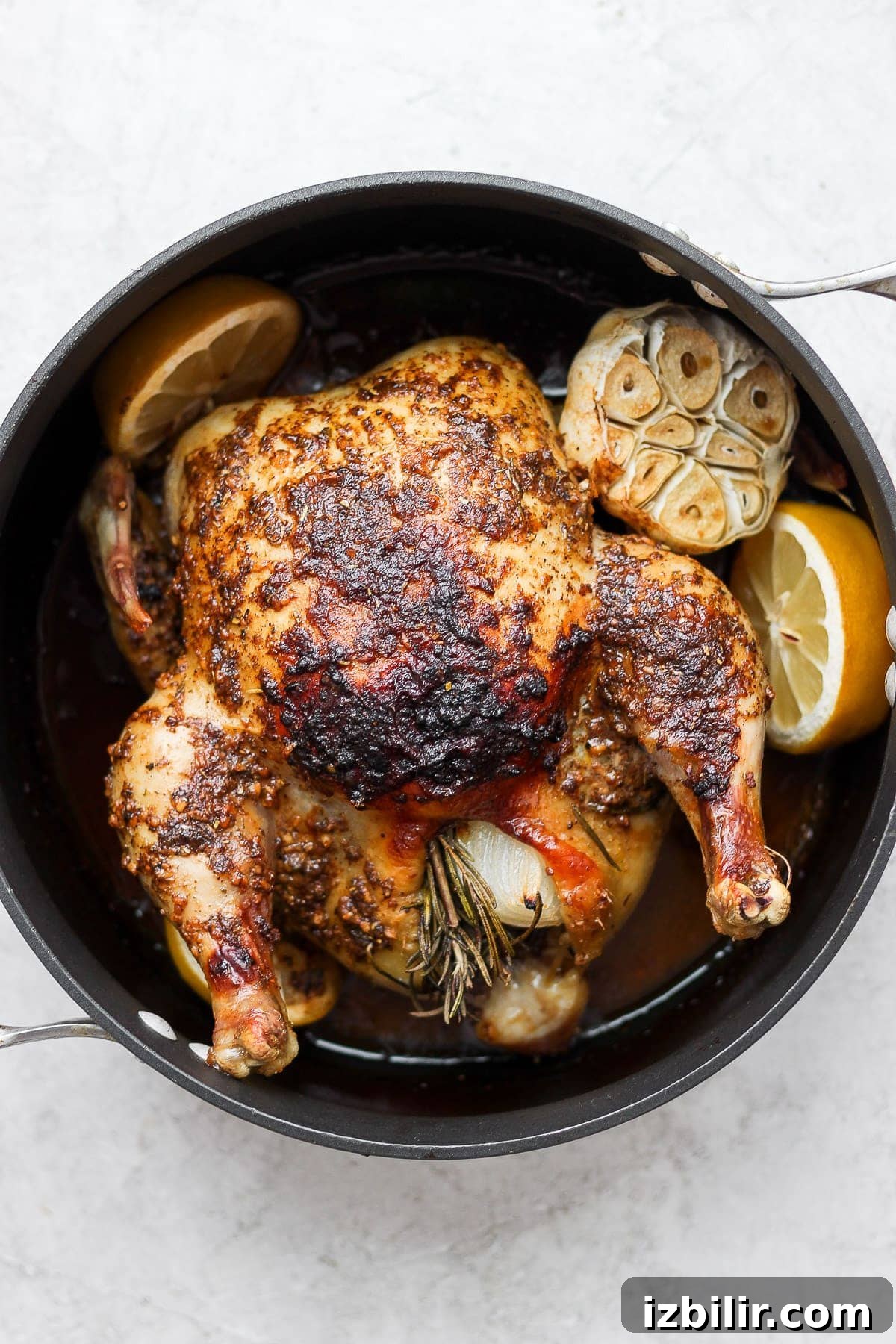 A herby whole roasted chicken ready to serve. whole roasted chicken in pan