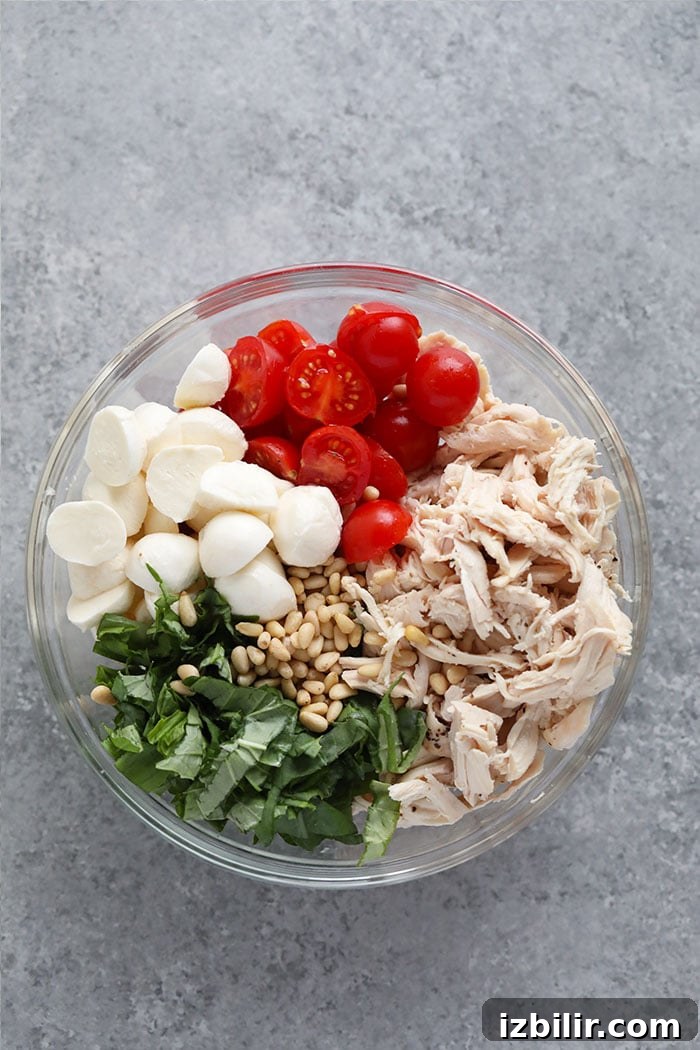 This creamy pesto chicken salad makes the perfect healthy lunch or easy weeknight dinner. It's easy to make and is packed with protein! Ingredients for pesto chicken salad in a bowl.