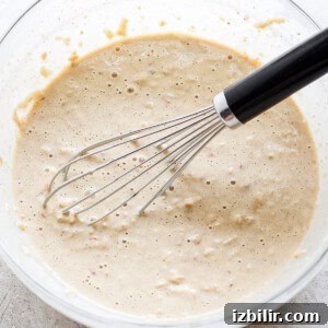 Fluffy Cinnamon Apple Pancakes with Caramel Sauce 9 a bowl of batter with a whisk in it.