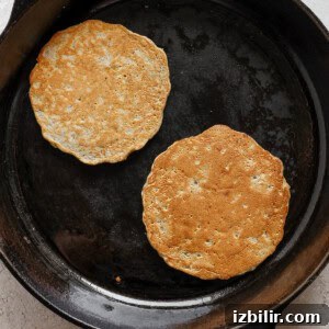 Fluffy Cinnamon Apple Pancakes with Caramel Sauce 10 two pancakes in a cast iron skillet.