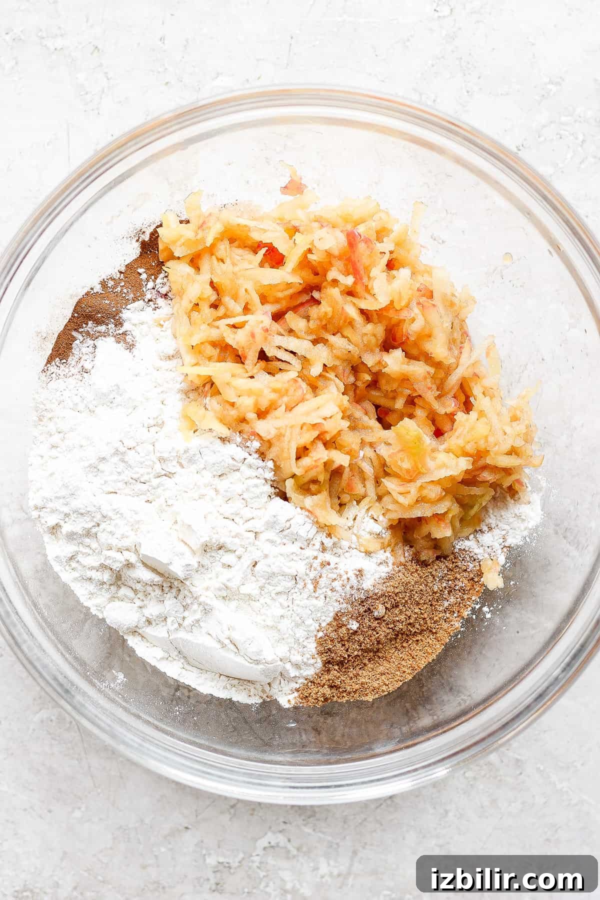 Fluffy Cinnamon Apple Pancakes with Caramel Sauce 4 a bowl filled with flour, carrots, and other ingredients.
