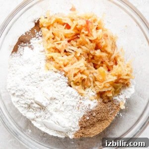 Fluffy Cinnamon Apple Pancakes with Caramel Sauce 8 a bowl filled with flour, carrots, and other ingredients.