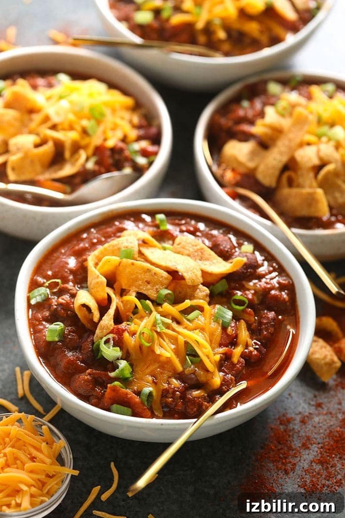 4 bowls of beef chili with Fritos on top.