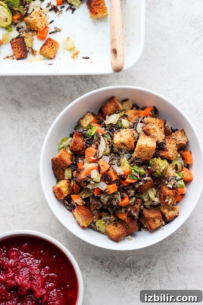 Cornbread stuffing in a bowl next to cranberry sauce