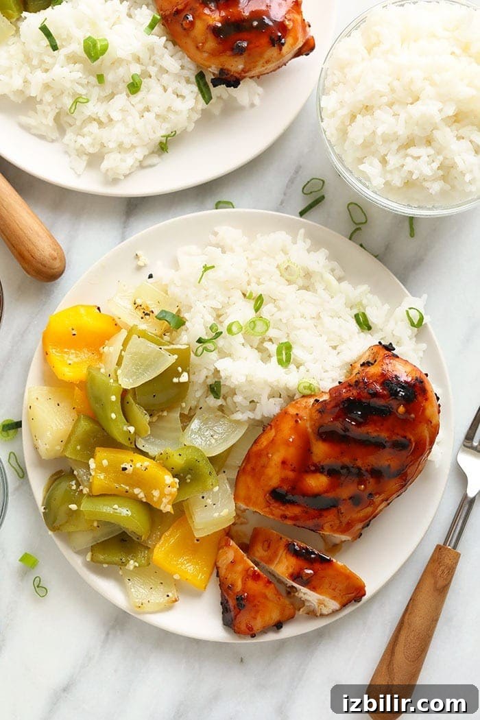 Grilled teriyaki chicken with rice and vegetables Grilled chicken plated with rice and vegetables