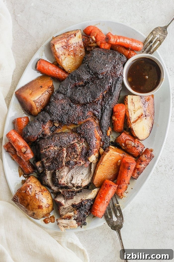 Slow cooker pork roast with vegetables. Pork roast on a platter with vegetables.