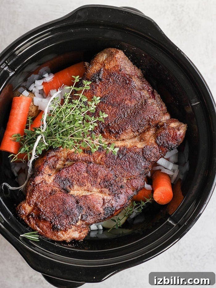 Pork shoulder cooking in slow cooker. pork shoulder in slow cooker.