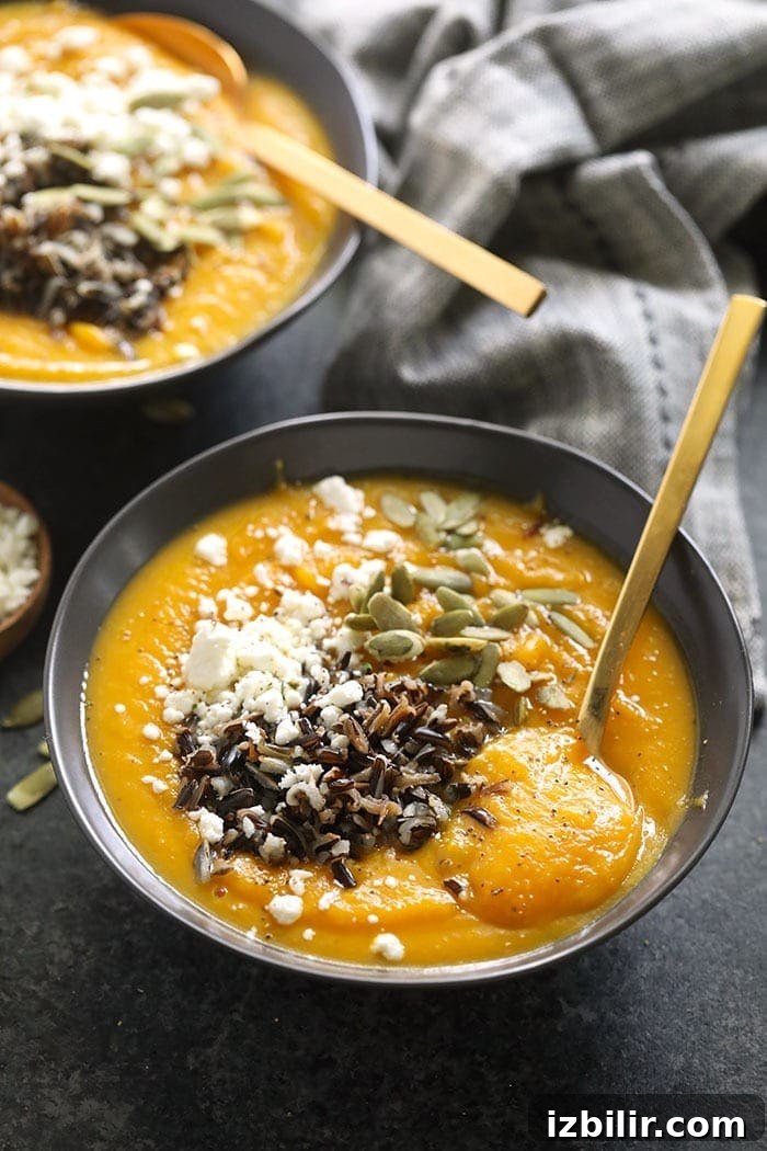 instant pot butternut squash soup in a bowl topped with wild rice and goat cheese