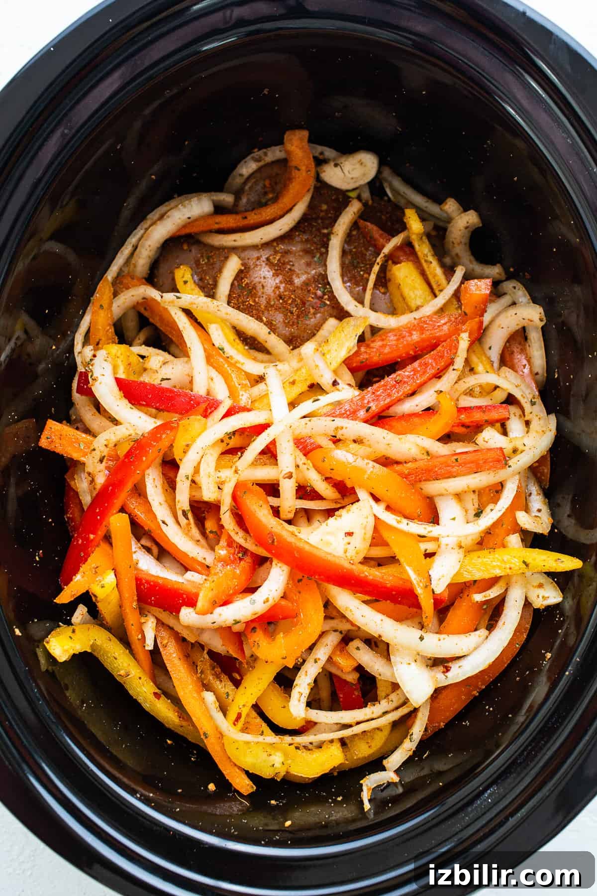 Slow Cooker Chicken Fajitas with Bell Peppers 5 A crock pot filled with peppers and onions.
