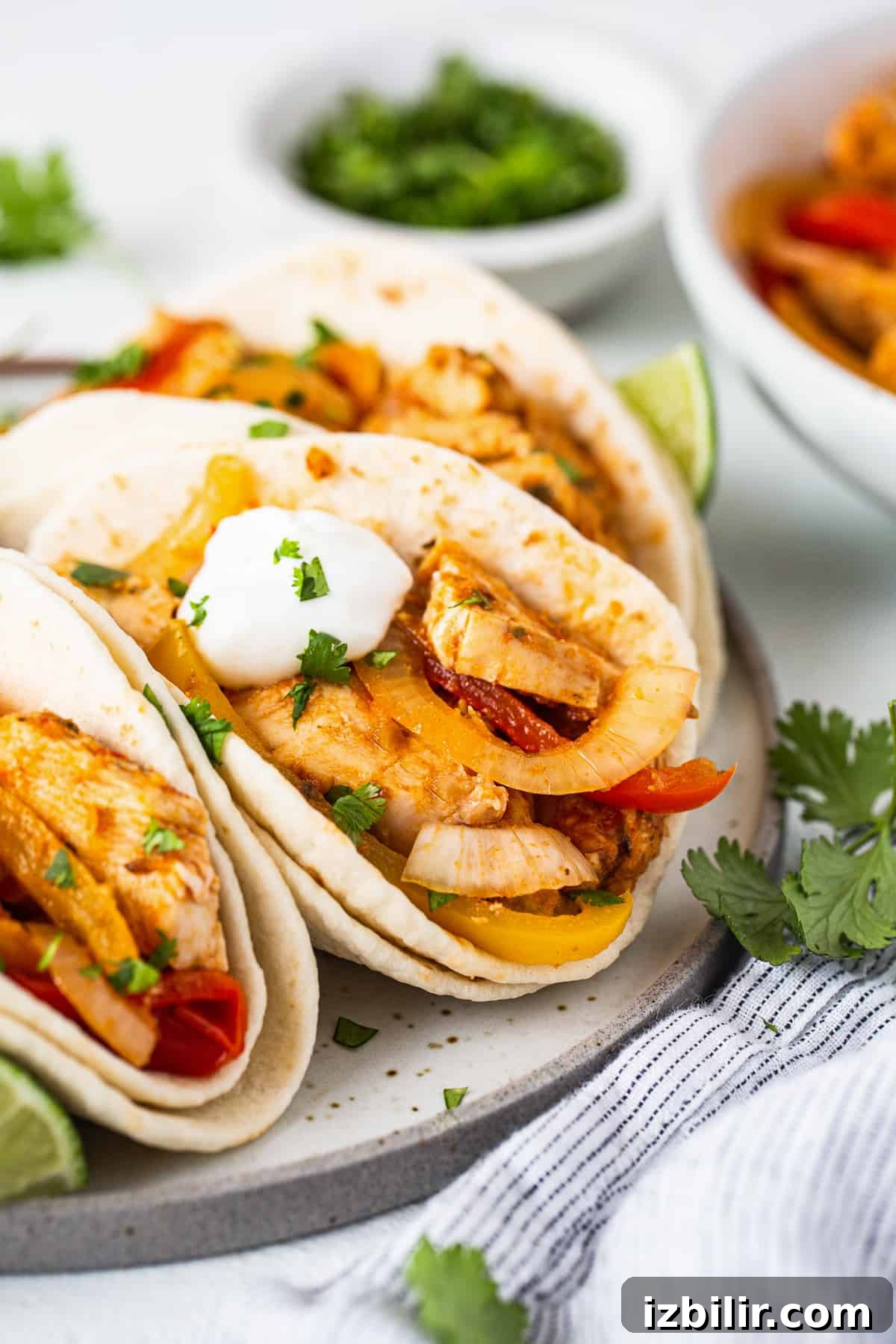 Slow Cooker Chicken Fajitas with Bell Peppers 9 Chicken tacos with peppers and sour cream on a plate.