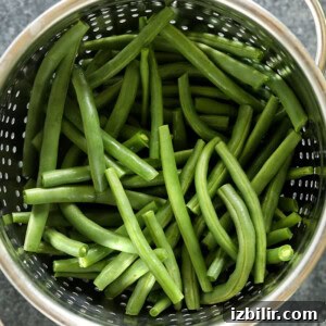Sauteed Green Beans Almondine with Toasted Almonds 2 Green beans in a colander, served almondine-style.