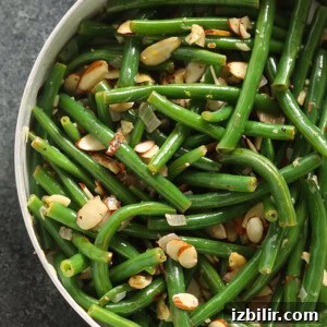 Sauteed Green Beans Almondine with Toasted Almonds 3 Green beans almondine cooked in a skillet.