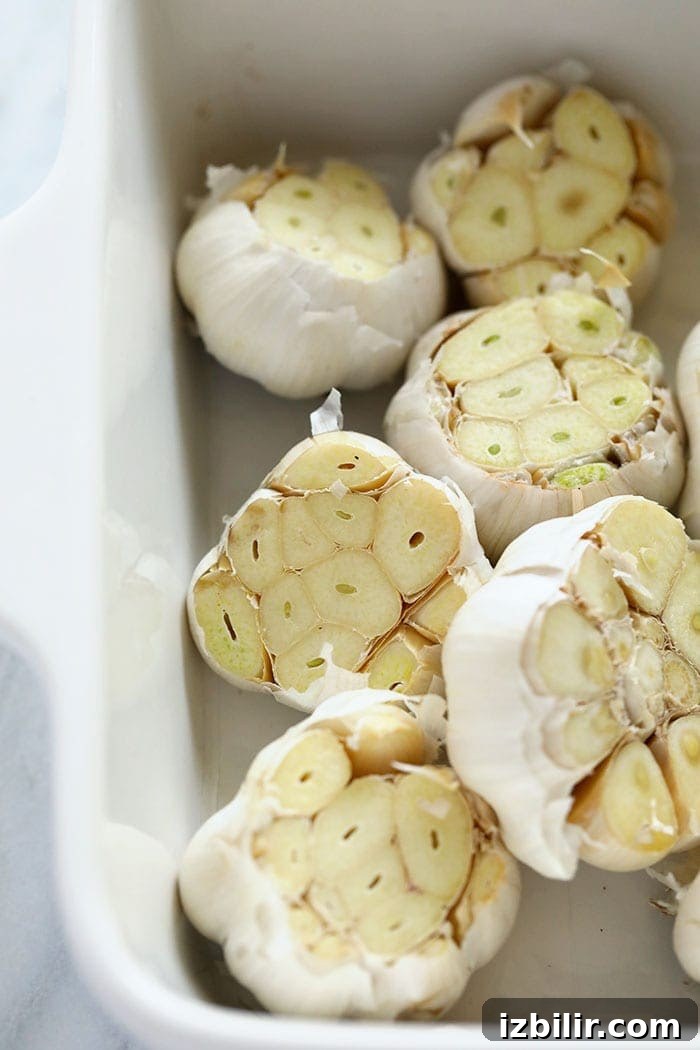 Roasting your own garlic could not be easier! fresh garlic bulbs ready to be roasted in a baking dish