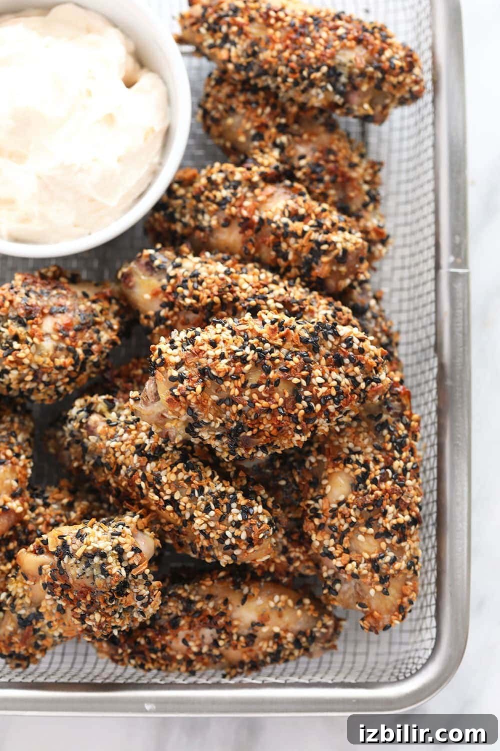 Everything Bagel Seasoning Wings in a basket with dip