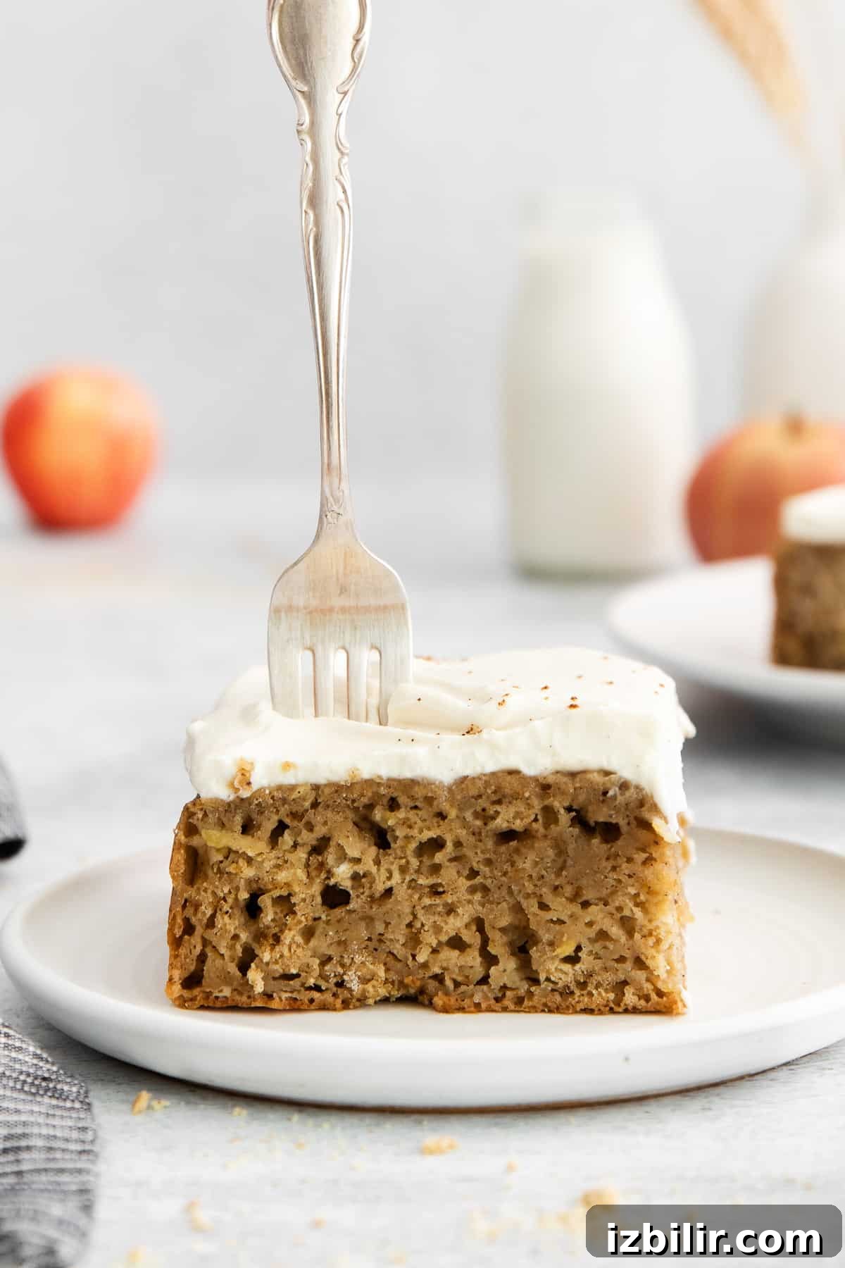 A piece of apple cake with a fork in it.