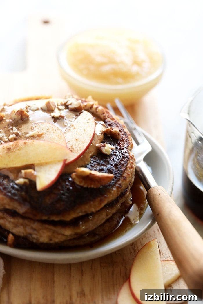 applesauce pancakes topped with apple slices ready to be eaten