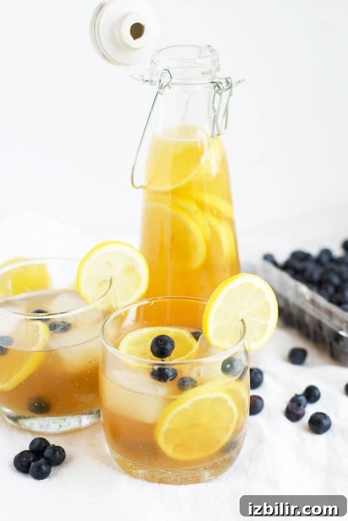 Kombucha Lemonade Recipe: Sparkling Homemade Citrus Cooler 2 Kombucha Lemonade in two cups and a pitcher