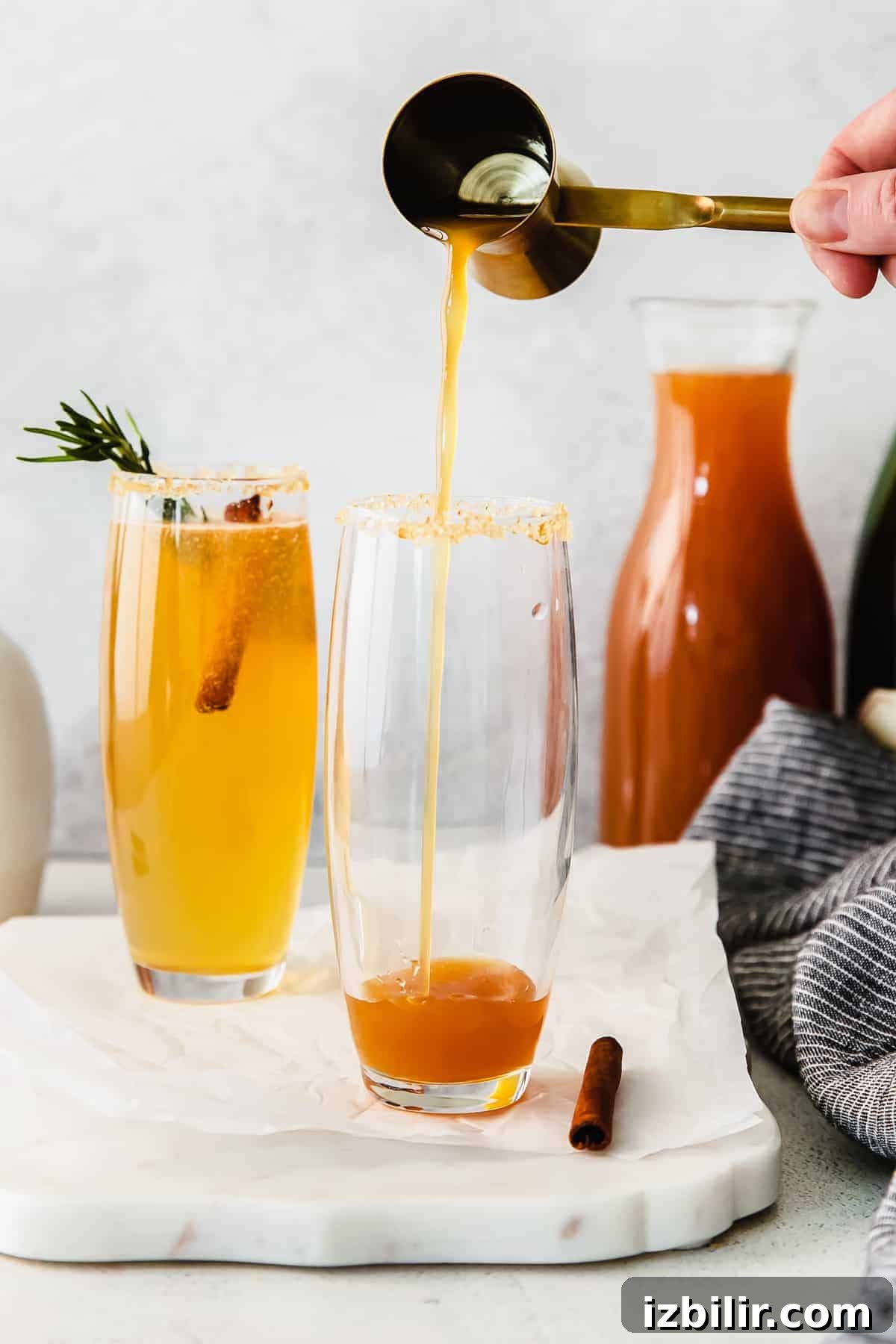 Sparkling Apple Cider Mimosa Recipe for Fall Brunch 5 Pouring an apple cider mimosa into a glass.