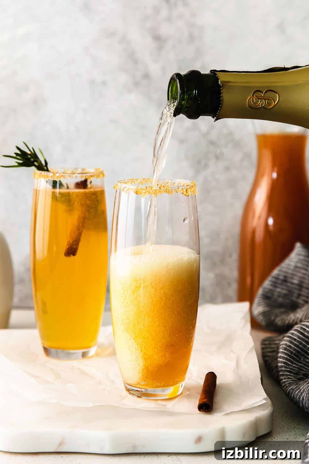 Sparkling Apple Cider Mimosa Recipe for Fall Brunch 6 Pouring champagne into a glass.