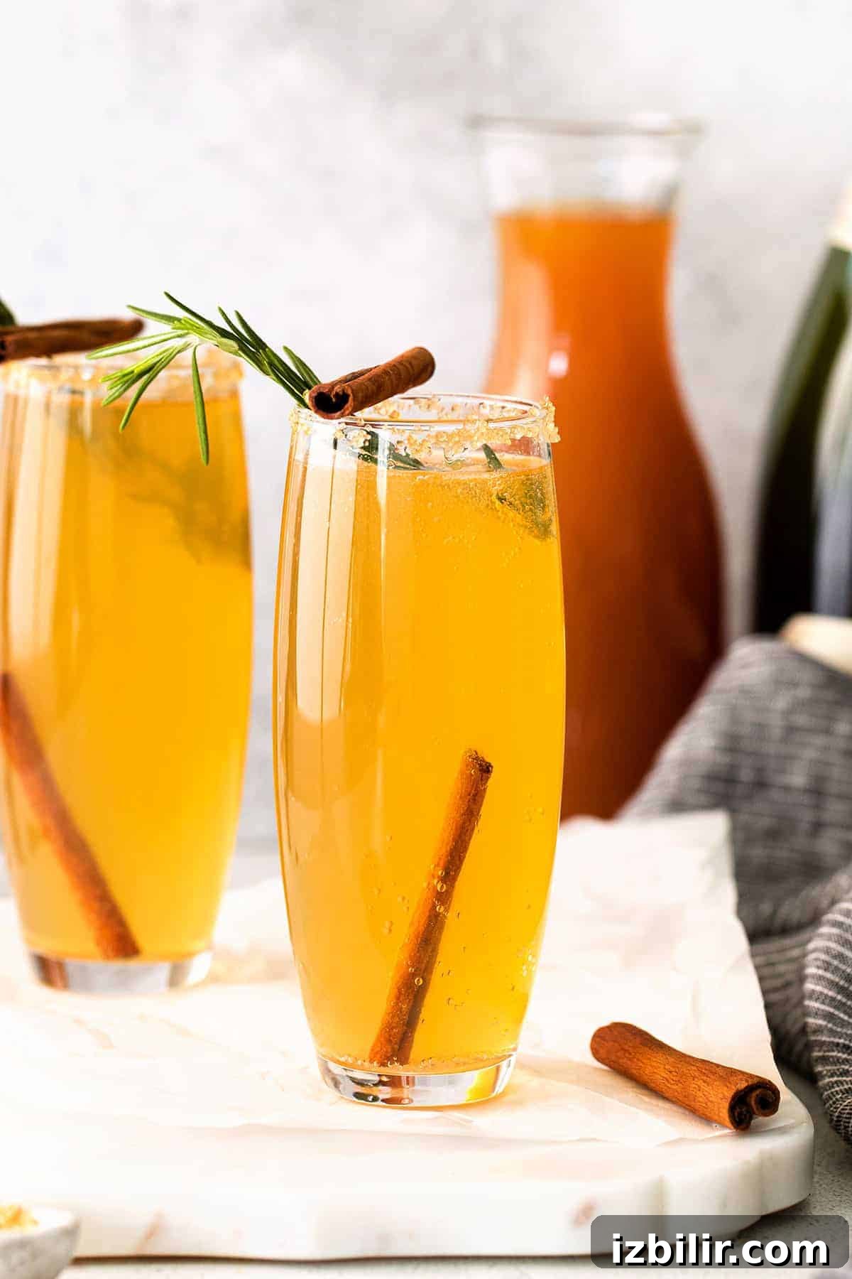 Sparkling Apple Cider Mimosa Recipe for Fall Brunch 7 Apple cider mimosa garnished with cinnamon sticks.