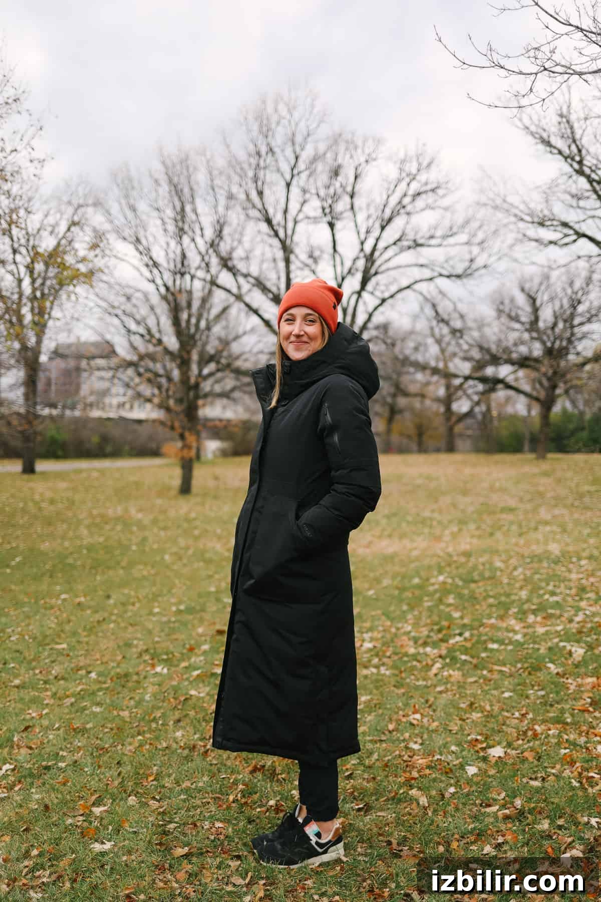 Woman wearing a long jacket smiling at the camera