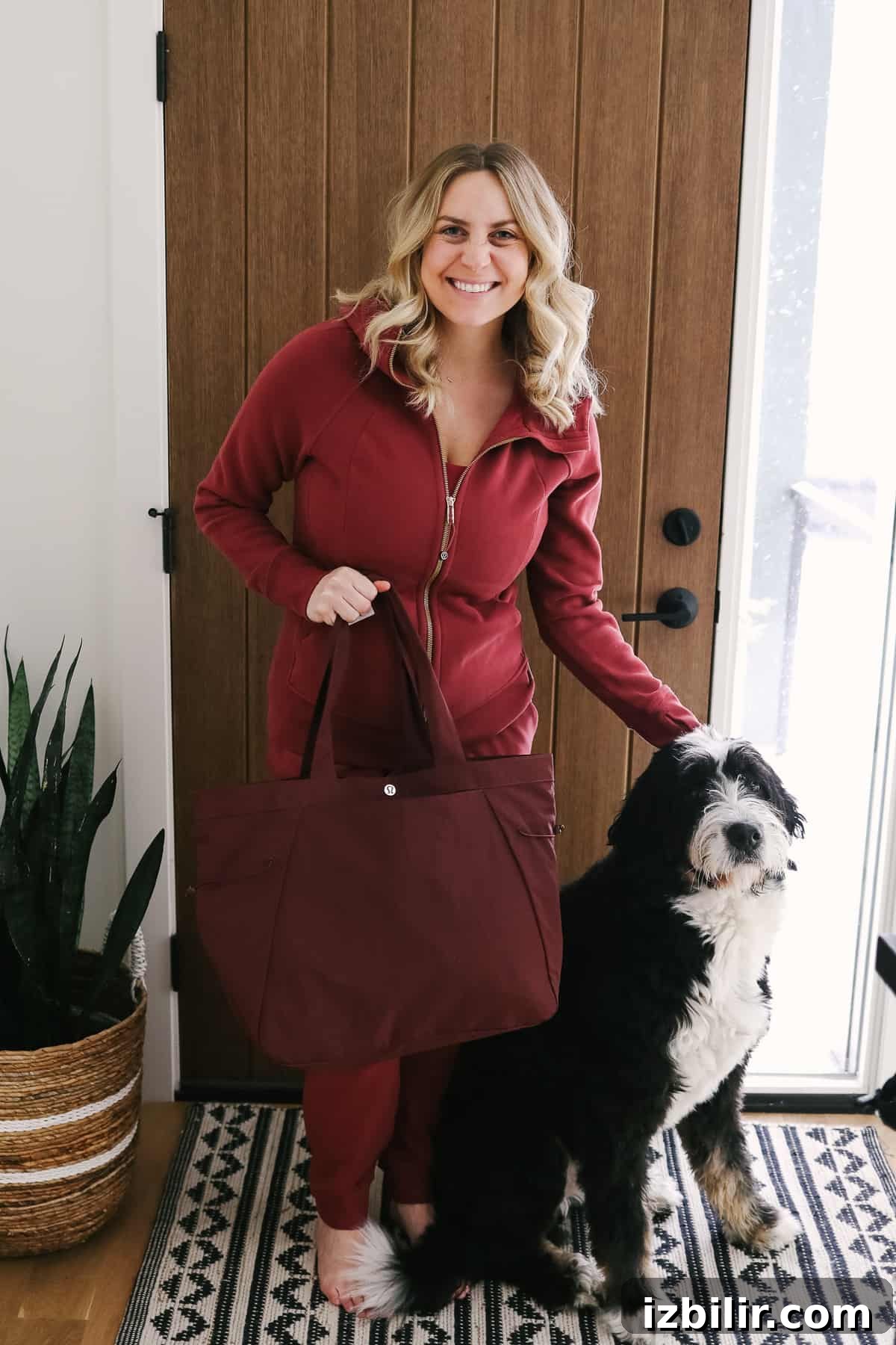 Woman carrying a slouchy bag standing next to a dog