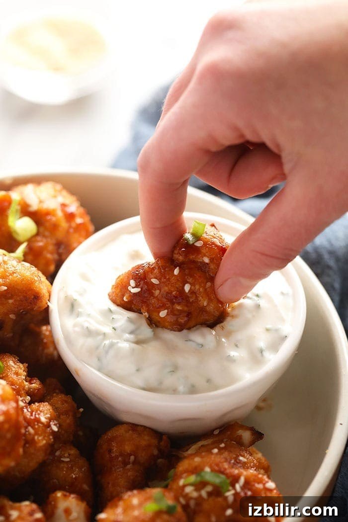 Dipping a cauliflower wing in dip Dipping a cauliflower wing in dip