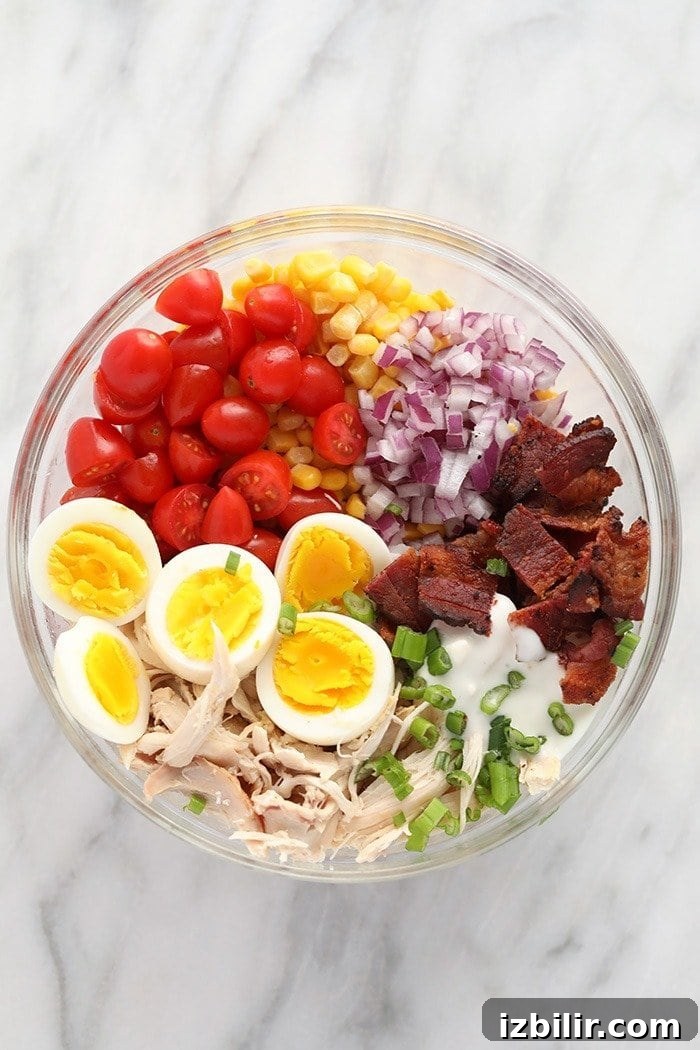 Ingredients ready to be mixed for Rotisserie Chicken Cobb Salad rotisserie chicken cobb salad ingredients in a bowl ready to be mixed