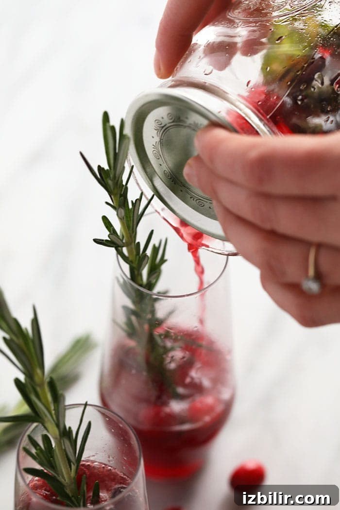 Pouring the cranberry mojito into a glass