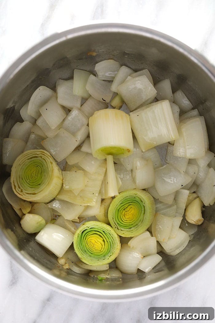 Sauté aromatics onions, leeks and garlic cloves being sautéed in the instant pot