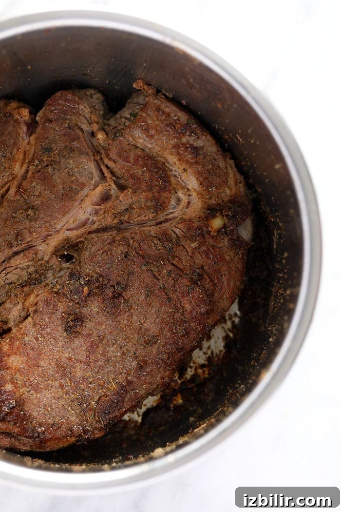 Sear the roast chuck roast being seared in the instant pot prior to pressure cooking