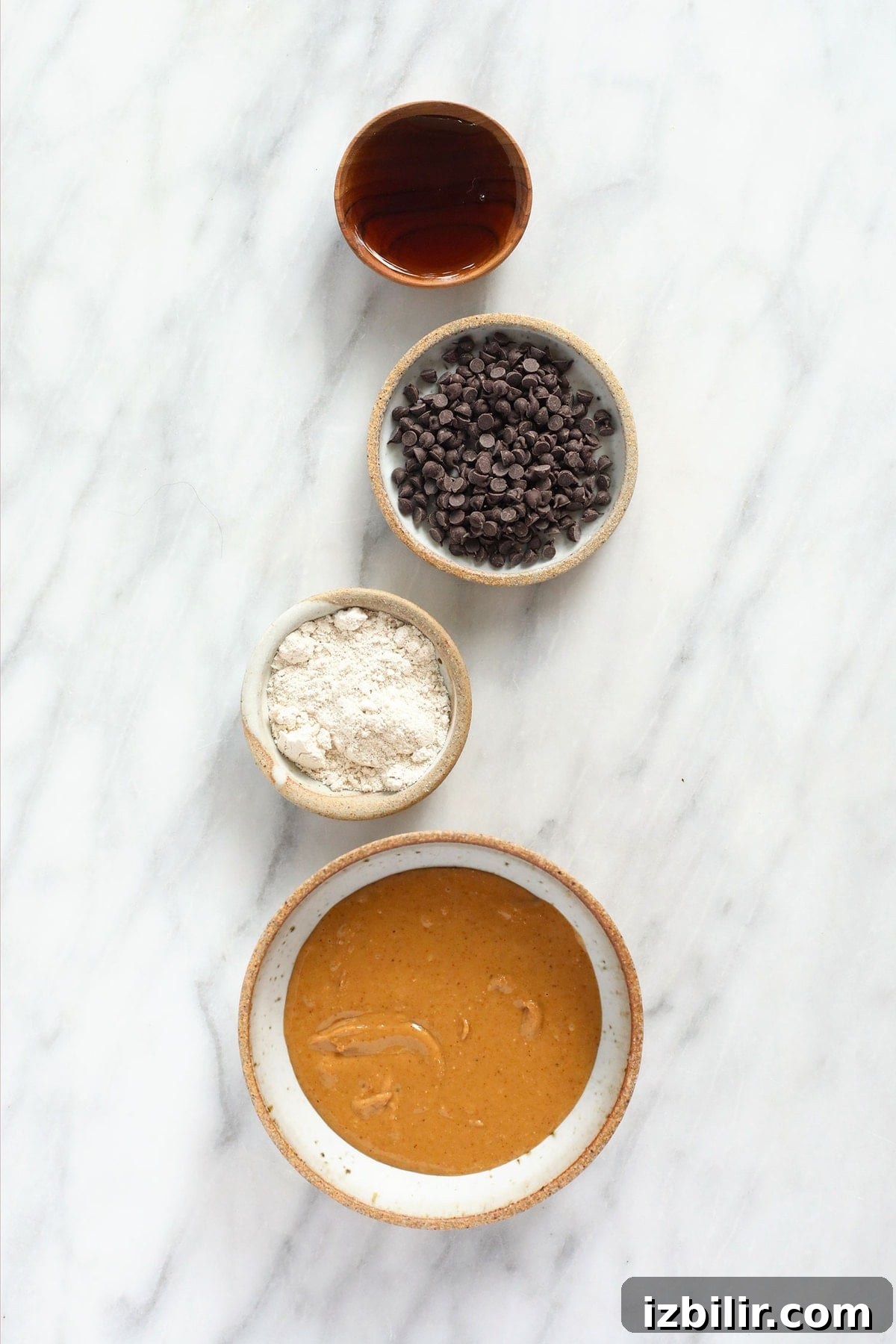 maple syrup, chocolate chips, oat flour, and peanut butter in bowls