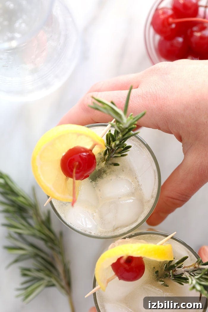 rosemary collins in a glass garnished with a sprig of rosemary