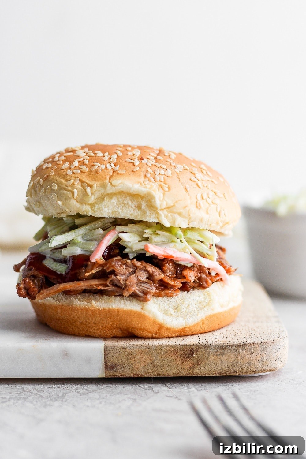 Tender Instant Pot Pulled Pork with dry rub and BBQ sauce Pulled pork on a bun with slaw