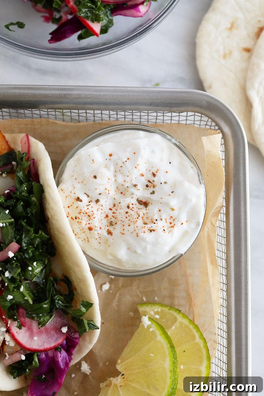 This baked fish taco recipe is flavorful, easy to make, and perfect for a 30-minute meal all year round! A dish of sauce for fish tacos