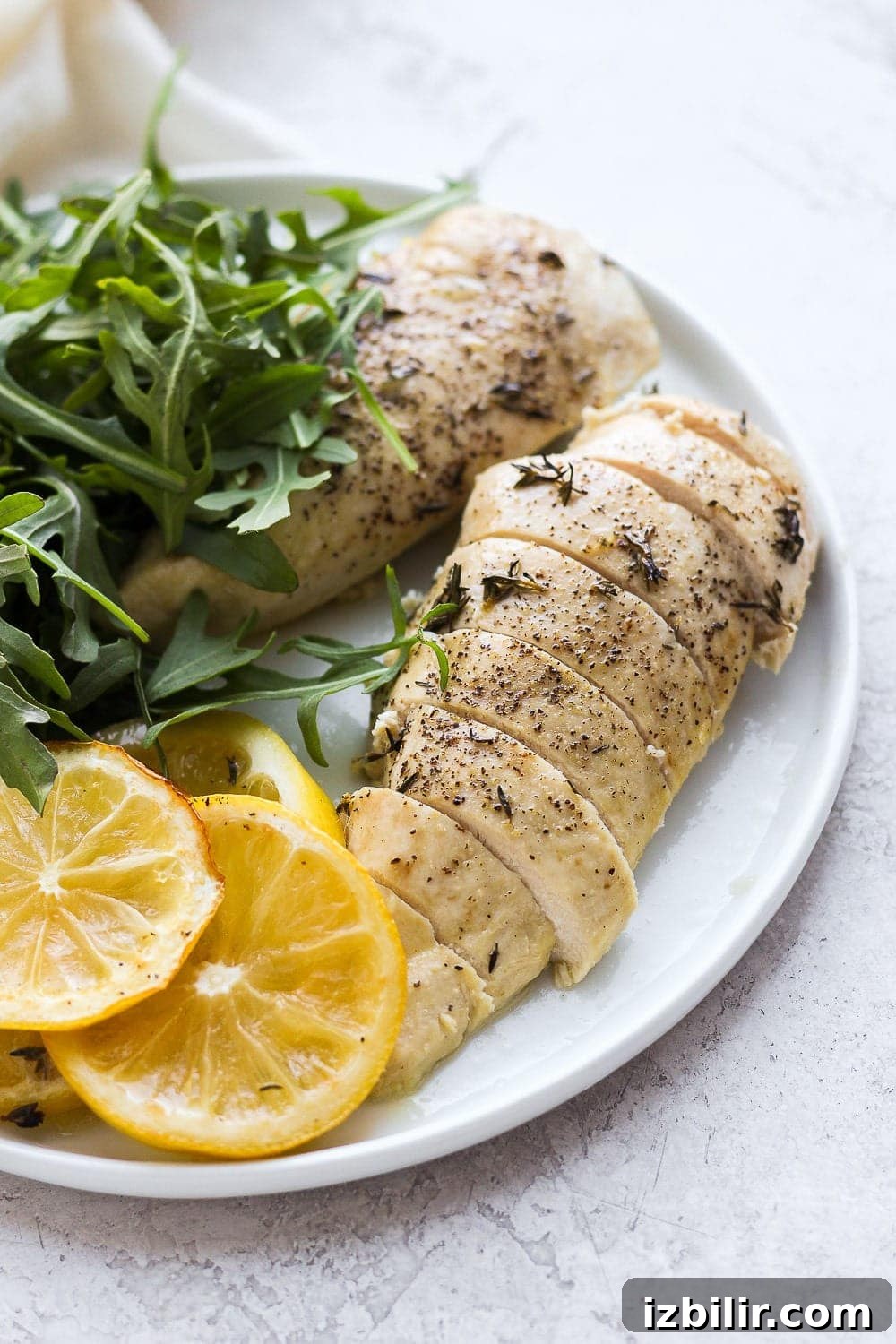Sliced baked lemon chicken on a plate.