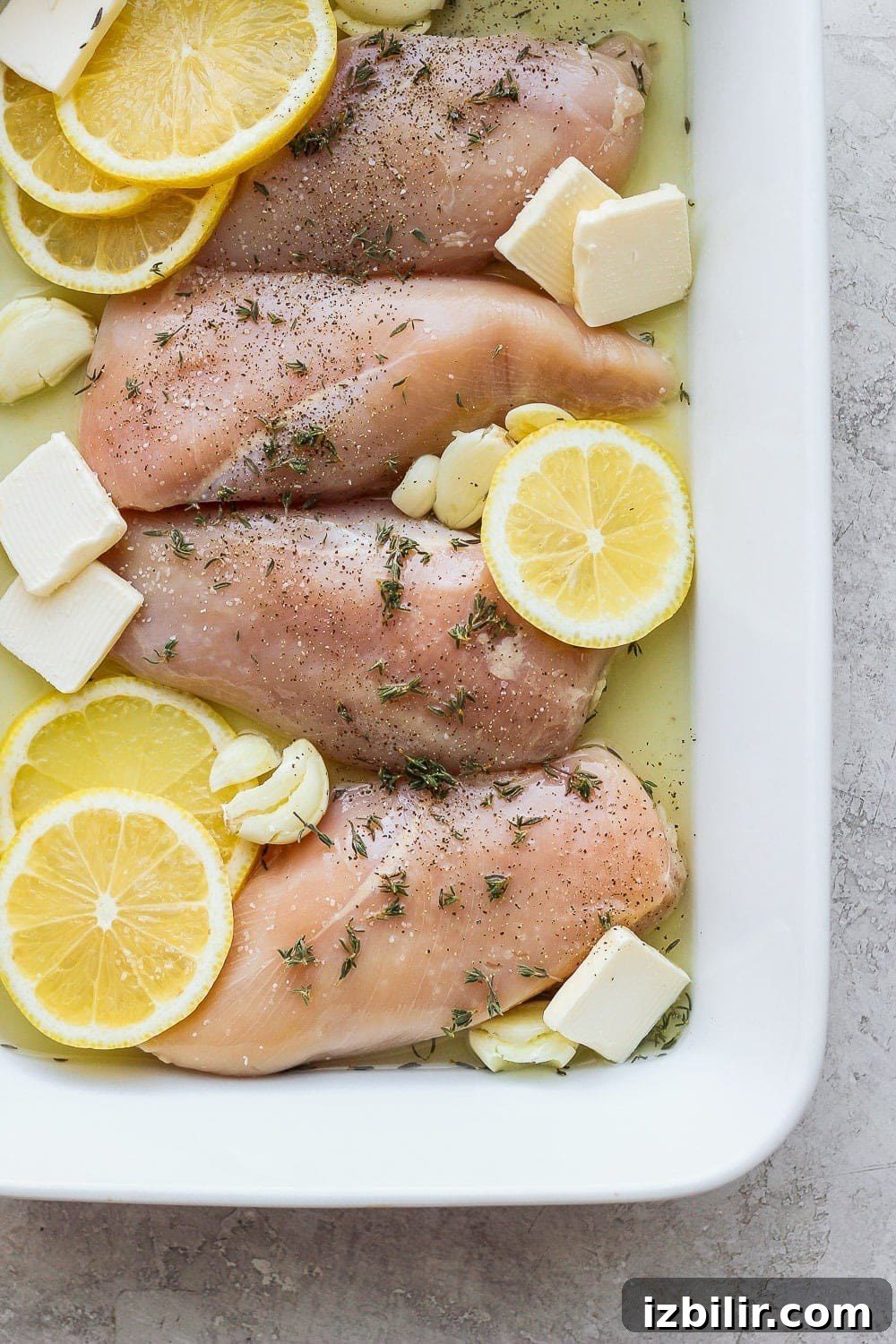 Raw chicken with lemon, garlic, and butter.
