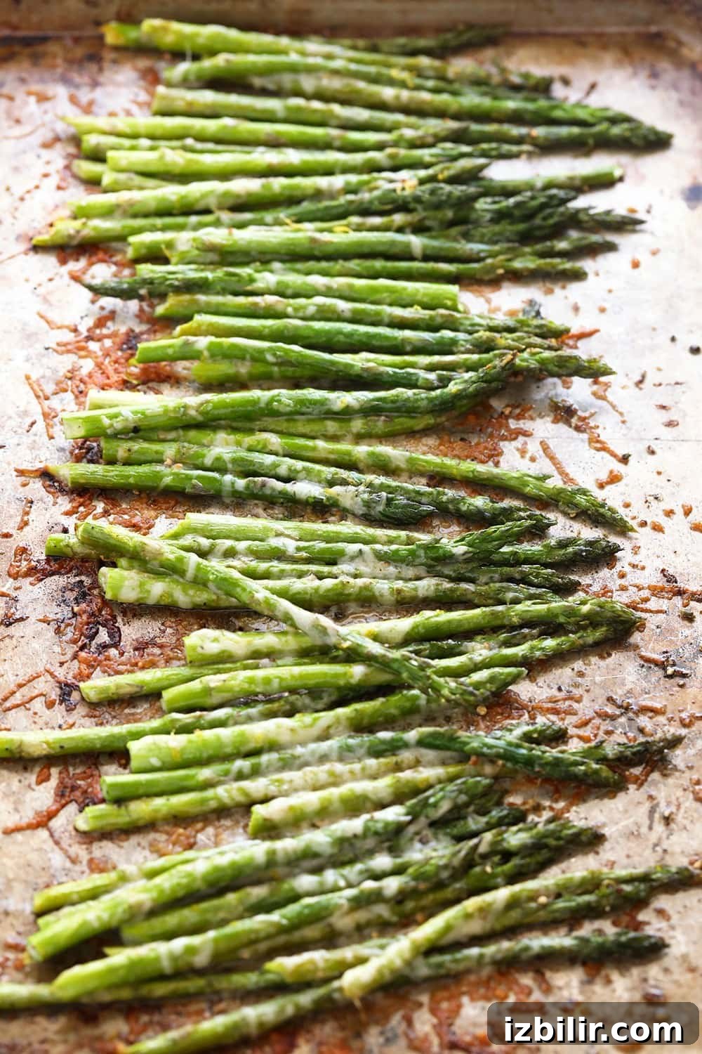 In just 10 minutes you can make perfectly roasted asparagus with parmesan cheese and a little lemon. Asparagus on a baking sheet.