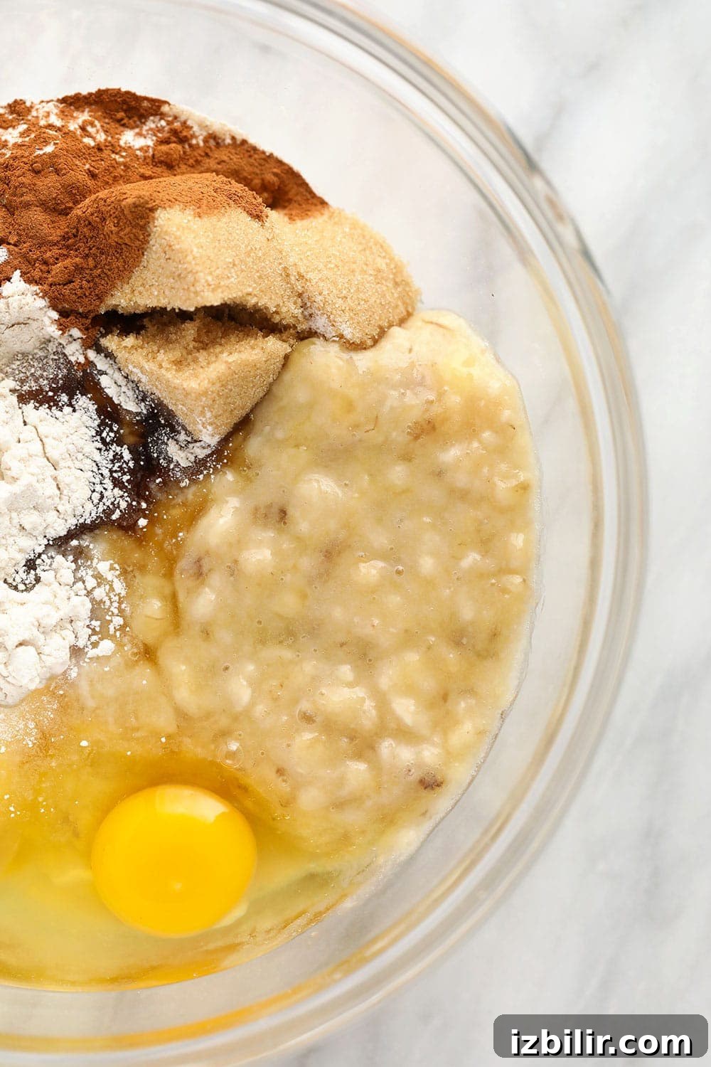 mashed banana and muffin ingredients in bowl