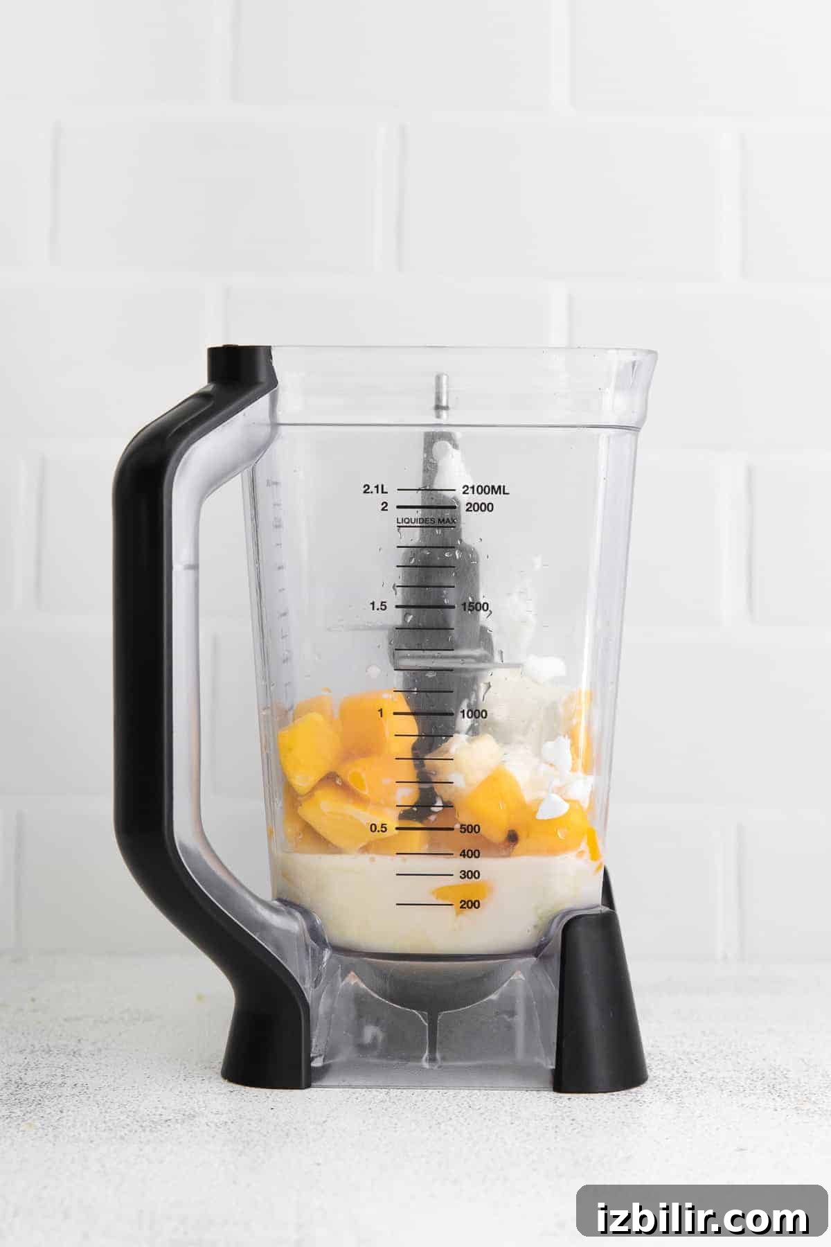 Creamy Mango Smoothie Recipe 4 Frozen mango and other ingredients in a high speed blender.