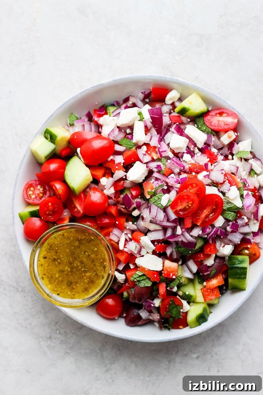 This Greek salad is made with sweet cherry tomatoes, cucumber, red onion, feta, and homemade Greek salad dressing! It is perfect for meal prep, a summer picnic, or just a healthy summer meal! Greek salad in a large bowl