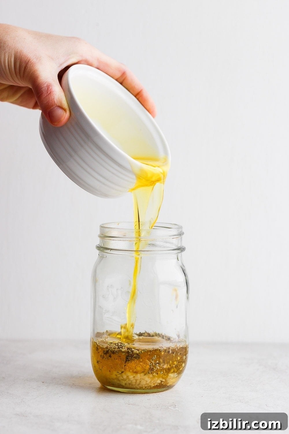 Pouring olive oil into a mason jar